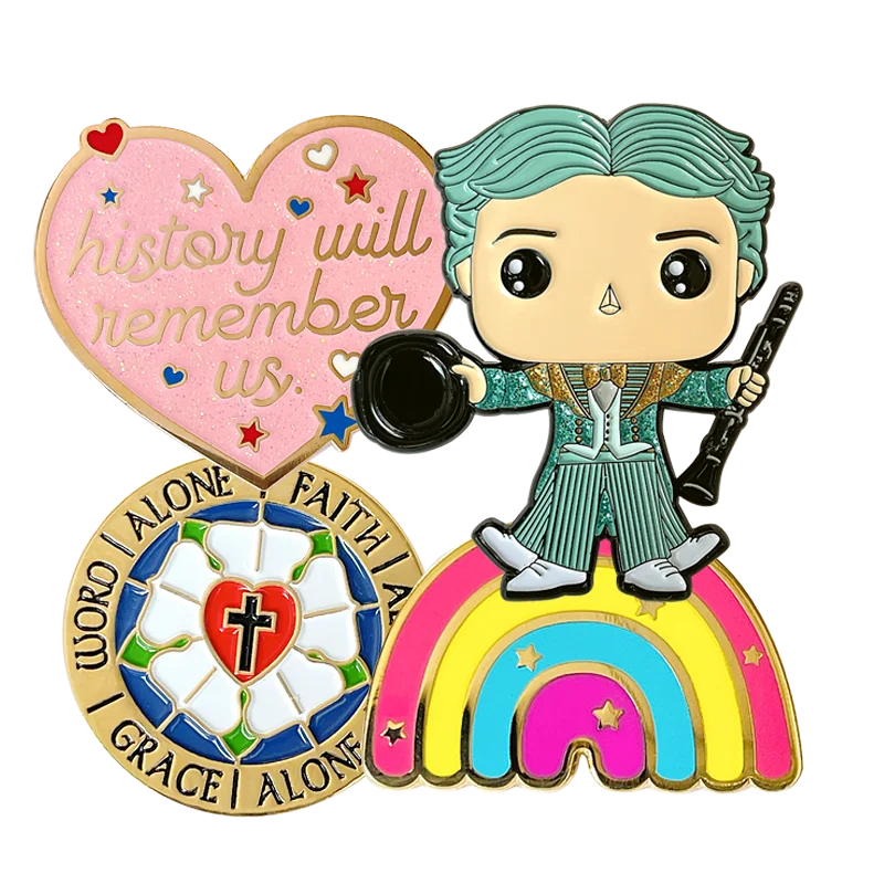 Collection of custom enamel pins including a pink heart with the text "history will remember us", a circular Luther Rose pin, and a character standing on a rainbow.