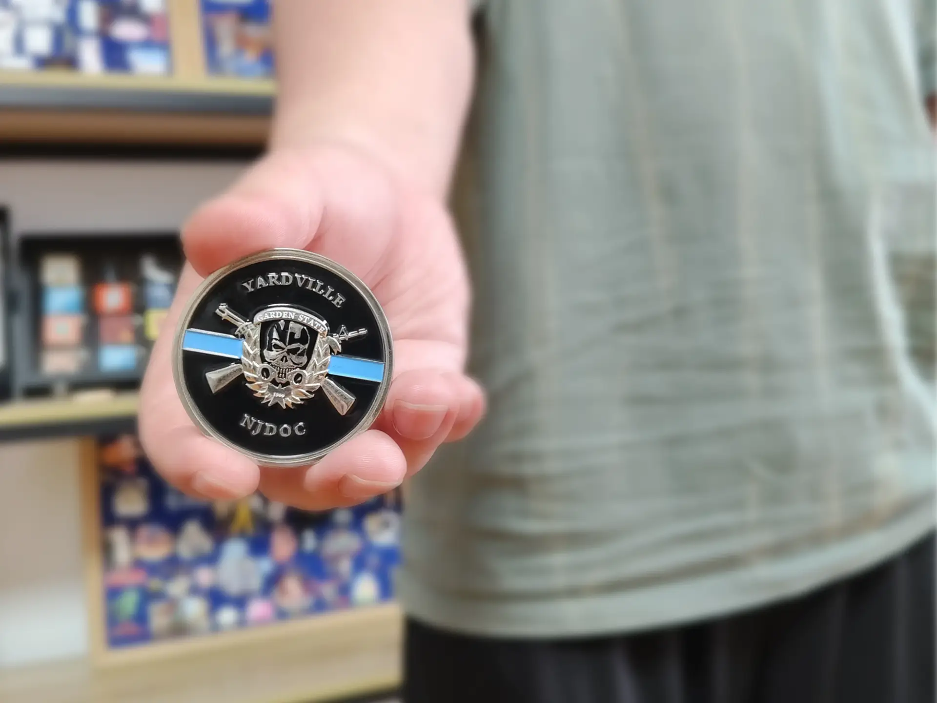 Custom enamel challenge coin close‑up, held in hand, detailed 3D metal emblem