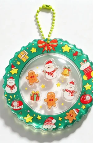 Christmas themed custom shaker acrylic keychain featuring floating snowmen, gingerbread men, and gift box charms inside a green wreath border with a green ball chain.