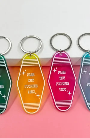 Collection of colorful transparent retro motel style acrylic keychains in green, yellow, pink, and blue, featuring funny white text and silver keyrings.