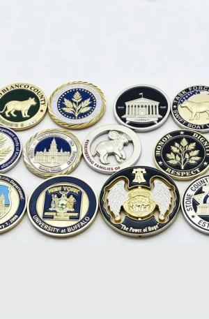 Custom challenge coin assortment displayed on a white background, featuring various military, university, county, and departmental emblems with diverse metallic finishes, coin edges, and enamel details.