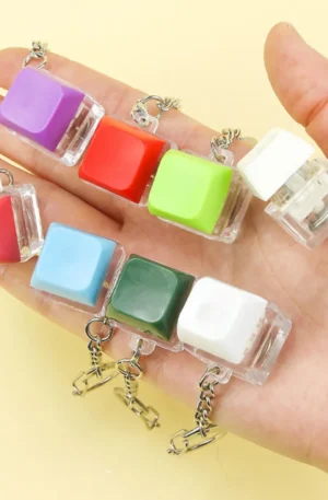 Hand holding a collection of colorful custom keycap keychains with mechanical switches and metal chains.