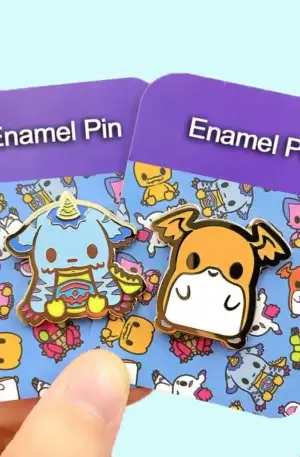 Custom enamel pin set featuring two cute monster character designs displayed on branded backing cards