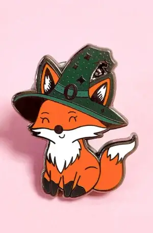 Custom enamel pin featuring a cute orange fox wearing a green witch hat with metallic finish