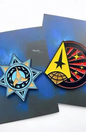 Custom enamel pin set featuring two sci-fi space emblems with blue star and yellow triangle designs on matching backing cards with metallic finish