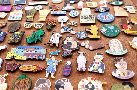 A massive collection of colorful custom enamel pins pinned on a cork board display